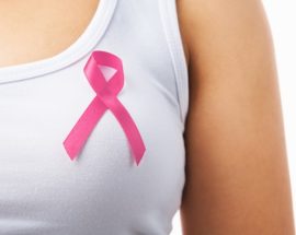 Pink badge on woman chest to support breat cancer cause