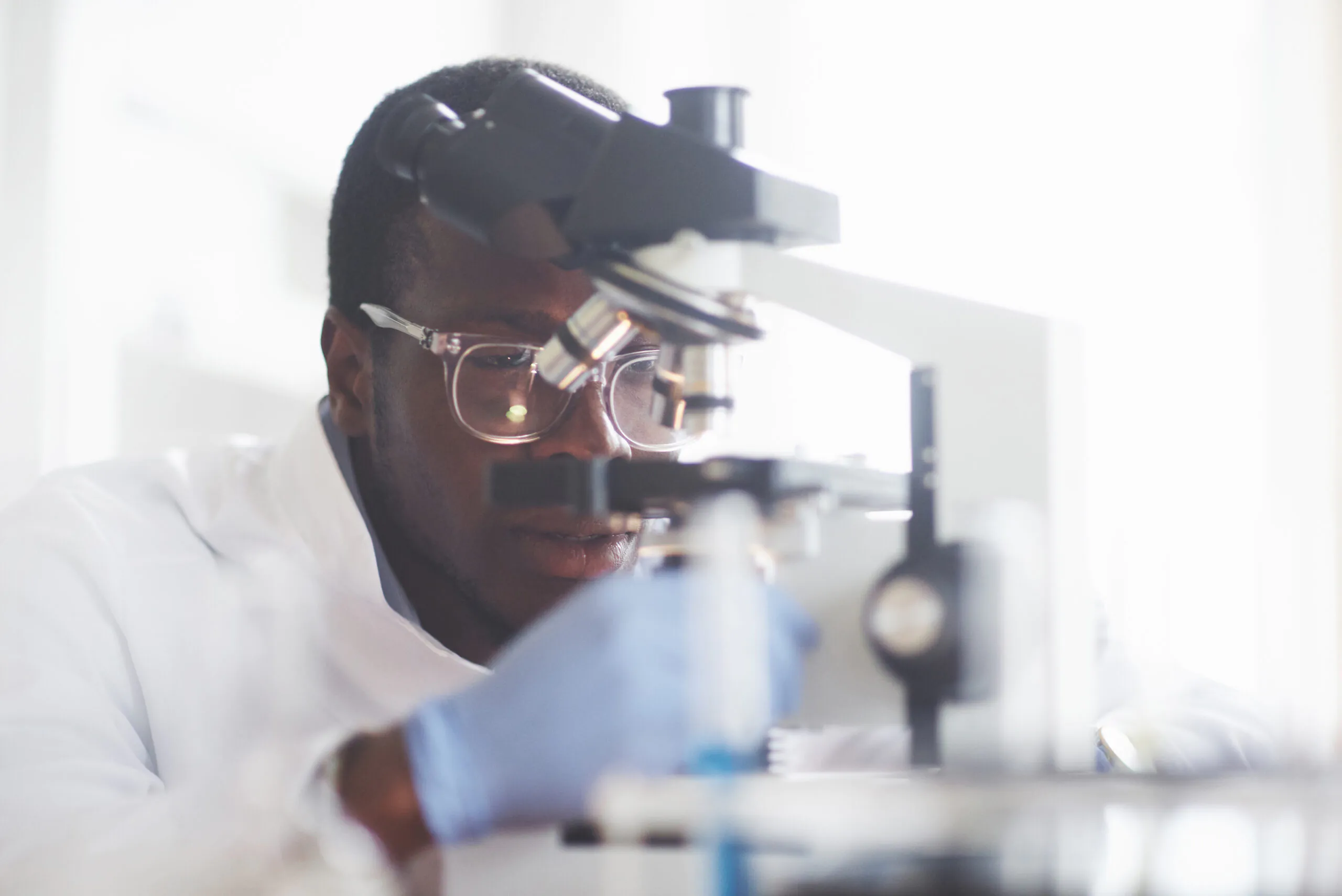 The scientist works with a microscope in a laboratory conducting experiments and formulas.