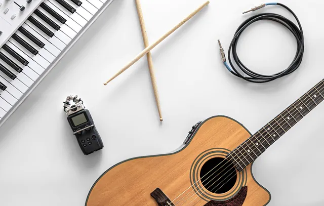 Acoustic guitar and musical keys on a white background, flat lay.