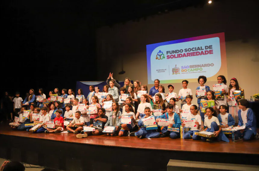 Alunos reunidos no palco para receber seu certificado e prêmio por  participarem do concurso