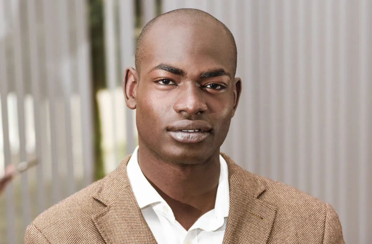 Cheerful young African man in formalwear keeping arms crossed