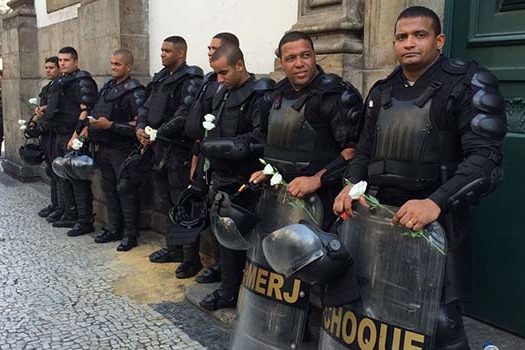 Manifestantes entregam flores a policias durante protesto no Rio