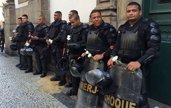 Manifestantes entregam flores a policias durante protesto no Rio