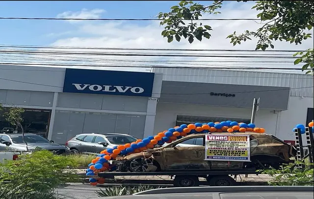 Carro de luxo pega fogo e dono coloca carcaça na porta de agência em BH