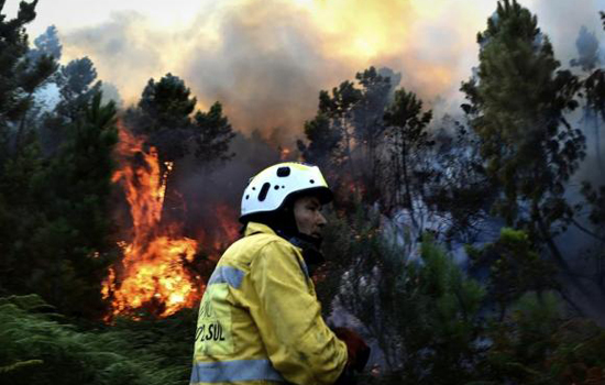 Bombeiro trabalha para apagar as chamas de incêndio nas montanhas de Manhouce