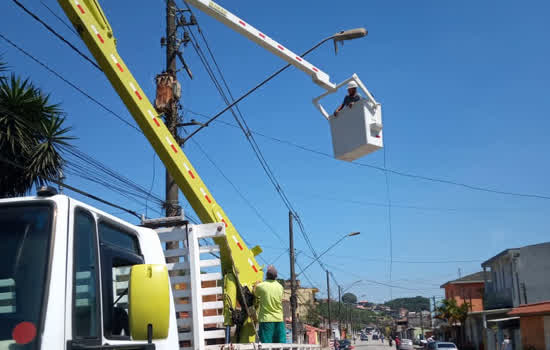 Funcionários da prefeitura realizam manutenção em poste de iluminação