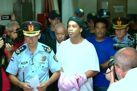 Ronaldinho Gaúcho e o irmão chegam algemados para audiência no Paraguai